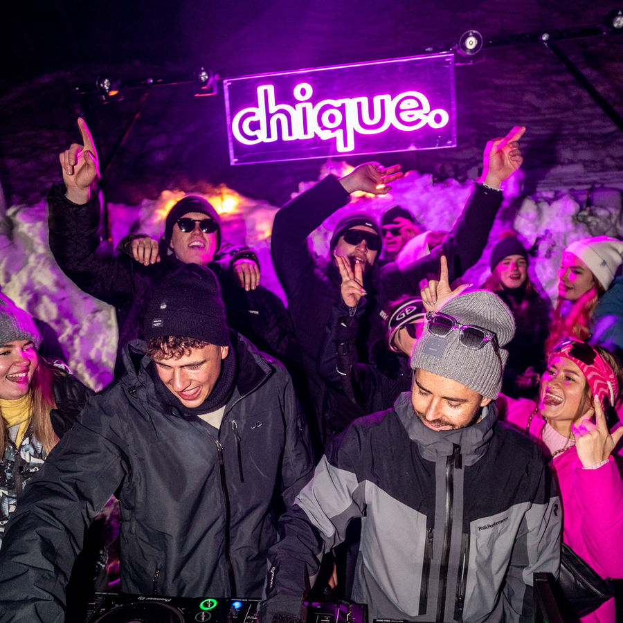 DJ und Crowd vor dem chique. Neonschild bei der Winter Edition